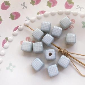Close-up of blue and white checkered cube beads with center hole for DIY jewelry making