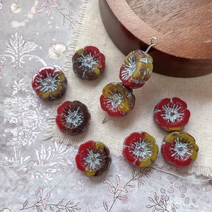 Macro detail of red and yellow gradient Czech glass flower beads for DIY jewelry crafts