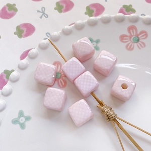 Macro detail of pink checkered ceramic square beads for DIY jewelry and phone chains
