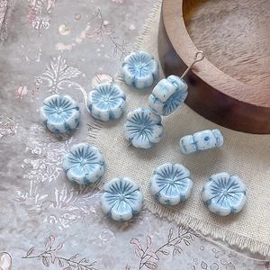 Macro shot of light blue glass flower beads with gold accents for DIY jewelry making