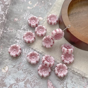 Detail of pink floral Czech glass beads with hand-painted gold on vintage linen