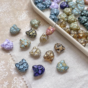 Assorted vintage Czech glass cat head beads for DIY jewelry making in multiple colors