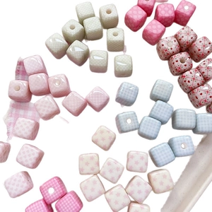 Mix of patterned ceramic cube beads with heart, plaid, and star prints for DIY jewelry