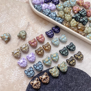 Detail of vintage cat head glass beads with crackle glaze for DIY jewelry making