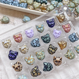 Macro view of vintage Czech glass cat head beads with embossed details for DIY jewelry