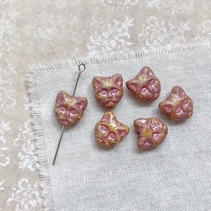 Macro detail of cat-head shaped Czech glass beads with vintage glaze and vertical holes
