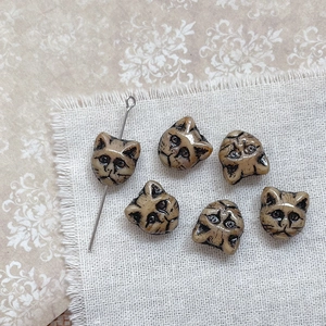 Detail of Czech vintage cat head glass beads with black outlines for DIY jewelry making