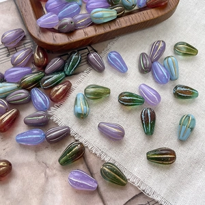 Close-up of matte Czech glass drop beads with gold trim for DIY jewelry making