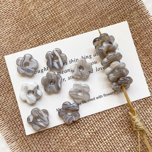 Detail of five-petal flower acrylic beads with grey marble texture for DIY jewelry making