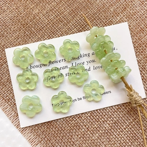 Macro view of translucent light green floral glass beads with central hole for DIY jewelry