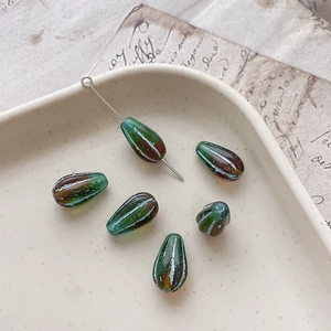 Macro detail of vintage forest green and brown teardrop glass beads for DIY jewelry