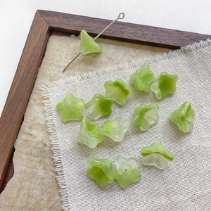 Macro shot of light green frosted glass trumpet flower beads for DIY jewelry making
