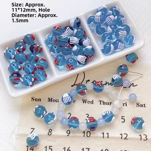 Detail of 11x12mm blue translucent glass beads with red star patterns for DIY jewelry