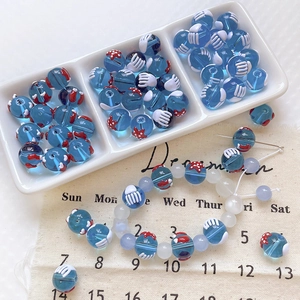 Détail de perles en verre bleu avec motif étoile de mer rouge et bijoux faits main