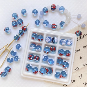 Vue détaillée de perles en verre bleu fait main avec accents nautiques rouges et blancs