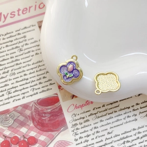 Détail macro du pendentif trèfle en alliage avec émail violet et motif de tulipe