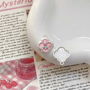 Gros plan de pendentifs trèfles émaillés avec tulipes roses pour bijoux DIY