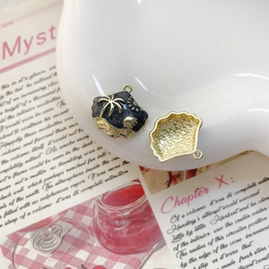 Détails d'un pendentif coquillage noir avec motifs de palmier et de soleil dorés