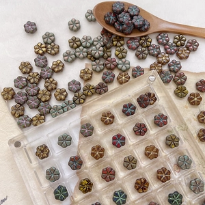 Gros plan de perles de verre tchèque en forme de fleur avec finition Picasso DIY