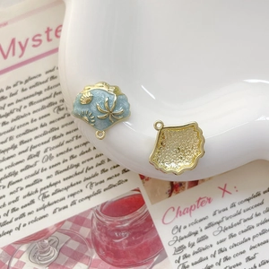 Vue macro de pendentifs en forme de coquillage bleu clair avec motifs de plage dorés gravés
