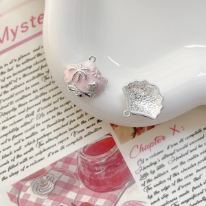 Vue détaillée de pendentifs coquillage en émail rose avec relief de palmier et soleil