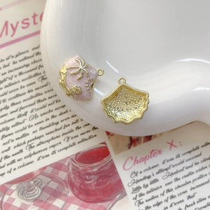 Détail de pendentifs coquillage rose avec motifs de palmiers dorés pour bijoux DIY