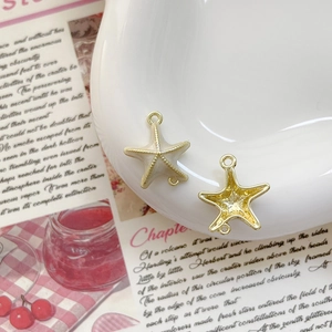 Détails macro de pendentifs étoile de mer avec doubles anneaux et finition émail jaune
