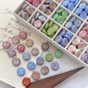 Flat round Czech glass daisy flower beads in various pastel colors with gold leaf edges