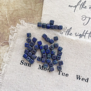 Macro view of blue Picasso Czech glass square beads with rustic texture for DIY crafts
