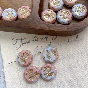 Detailed macro of vintage Margaret floral glass beads with gold embossed patterns for DIY