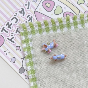 Detail von niedlichen Dackel-Anhängern mit blauem Punktemuster für DIY-Schmucksets