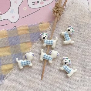Close-up of five cute cartoon puppy charms with blue plaid pattern for DIY jewelry