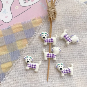 Close-up of five cute purple plaid puppy resin beads for DIY jewelry handmade crafts