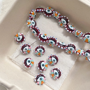 Macro view of colorful evil eye glass beads and a beading needle for DIY jewelry making