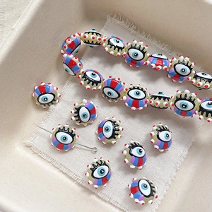 Macro shot of striped evil eye glass beads on linen for DIY jewelry making