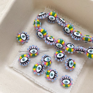 Detailed view of colorful evil eye glass beads with eyelash accents for DIY jewelry making