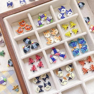Macro view of cartoon bird and cat alloy beads with colorful patterns in a velvet display tray