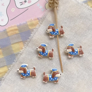 Close-up of five cute resin cartoon dog charms with blue star patterns for DIY jewelry