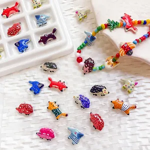 Macro dettagliata di perline colorate a forma di animale con motivi di riccio e volpe per fai da te
