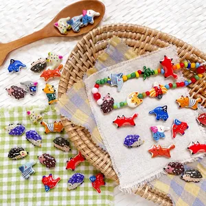 Dettaglio di ciondoli animali colorati come riccio e volpe per gioielli fai-da-te