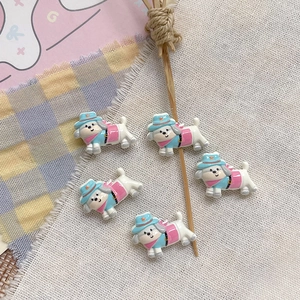 Close-up of five cute resin puppy figurines wearing hats for DIY jewelry and crafts