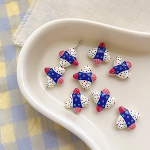 Detailed view of colorful cartoon bird ceramic beads with polka dots on a ceramic tray