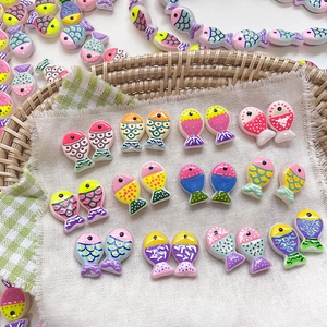 Macro detail of colorful resin fish beads with hand-painted dots for DIY jewelry making