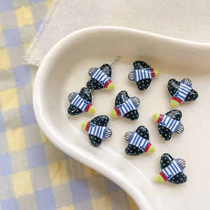 Macro detail of bird-shaped alloy beads with vibrant stripes and polka dot patterns