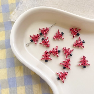 Macro detail of red Christmas tree alloy beads with black polka dots for DIY jewelry making