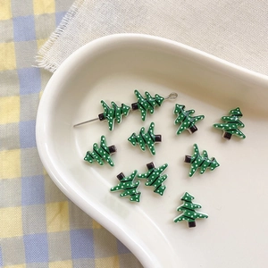 Macro detail of Christmas tree ceramic beads with white polka dots for DIY jewelry