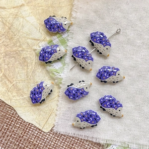 Dettaglio di perline a forma di riccio viola in resina per la creazione di gioielli