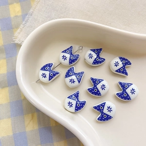 Macro detail of blue and white ceramic cat beads for DIY jewelry making and crafts