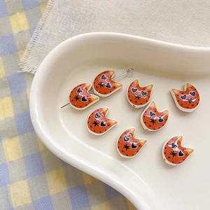 Detailed view of orange ceramic cat-shaped beads with heart eyes for DIY jewelry making