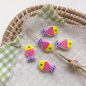 Detail of colorful hand-painted glass fish beads for DIY jewelry making and crafts
